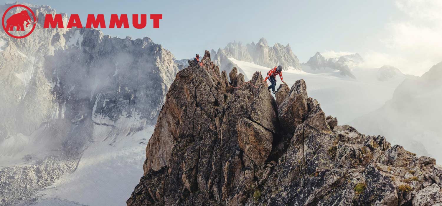 Verschneite Bergkulisse mit Mann auf dem Gipfel