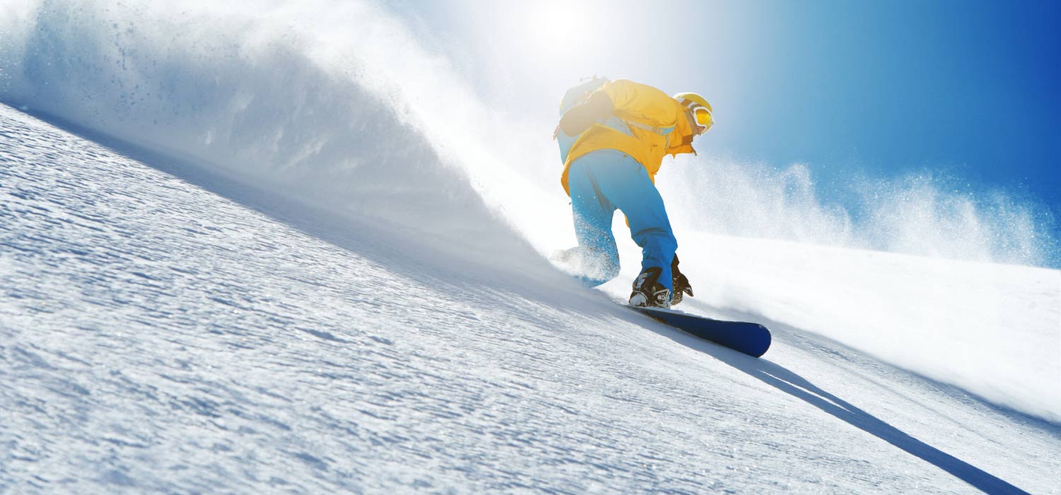 Snowboardfahrer in Action bei strahlend blauem Himmel