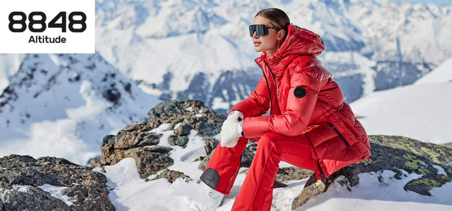 Frau in rotem Skioutfit in den Bergen